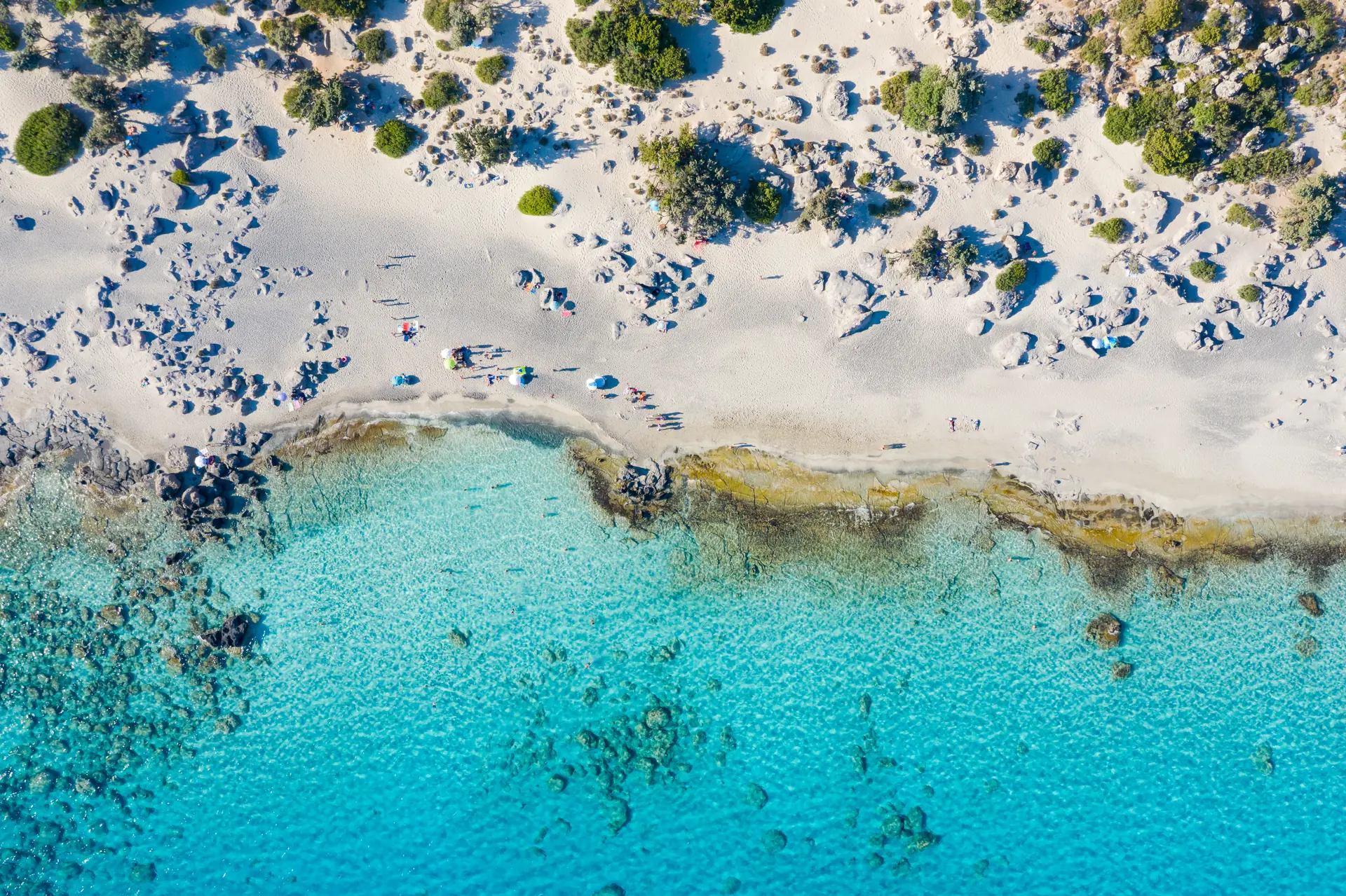 Aerial view of turquoise water and shoreline at Kedrodasos Beach in Chania, Crete.
